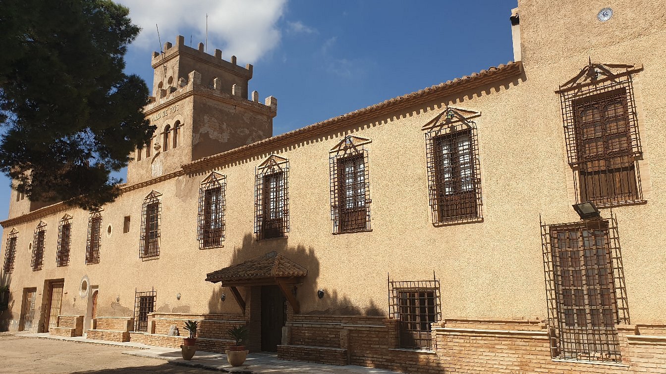 The Castillo Palacio del Vizconde de Ros, commonly known as Ros Castle, was originally built at the request of the Order of Saint Philip Neri. It initially formed part of the historic Balsicas estate before becoming property of the Spanish State. It was later granted to General Antonio Ros de Olano y Perpiñá. In recognition of his distinguished service, Queen Isabella II of Spain bestowed upon him the noble titles of Viscount of Ros de Olano and Marquis of Gaud-el-Yehi, together with the prestigious rank of Grandee of Spain. Over the years, the palace underwent several renovations under the direction of Don Antonio de Vega y Ros de Olano, the General's grandson. He inherited both the estate and the title of Viscount from his mother, Doña Isabel Ros de Olano y Quintana de Romo. The building is a historic country manor distinguished by its characteristic crenellated tower, reflecting its noble heritage and architectural charm. Today, Ros Castle remains privately owned and is not open to the public, but it continues to stand as one of Balsicas' most remarkable historic landmarks.